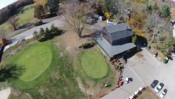 This is the Locust Valley clubhouse from 125' up with a view of the clubhouse, practice green and second green.  